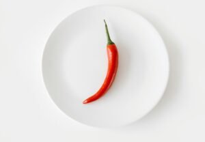 Pimenta dedo-de-moça vermelha madura sobre prato branco — cultivo de pimenta em vaso