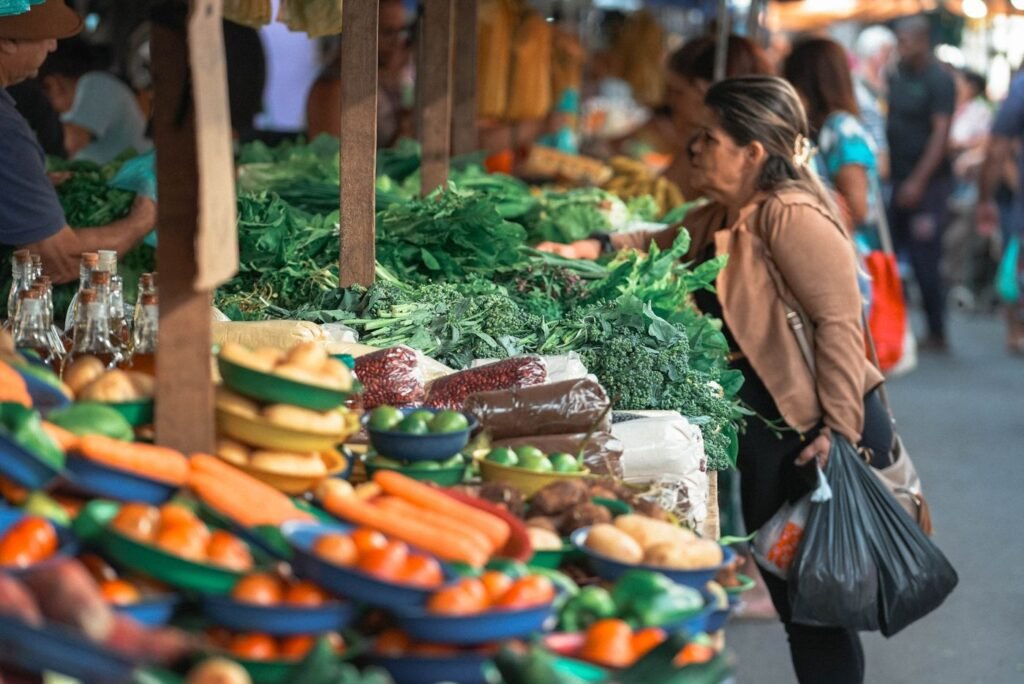 Mulher escolhendo verduras e legumes em uma banca de feira livre no Espírito Santo