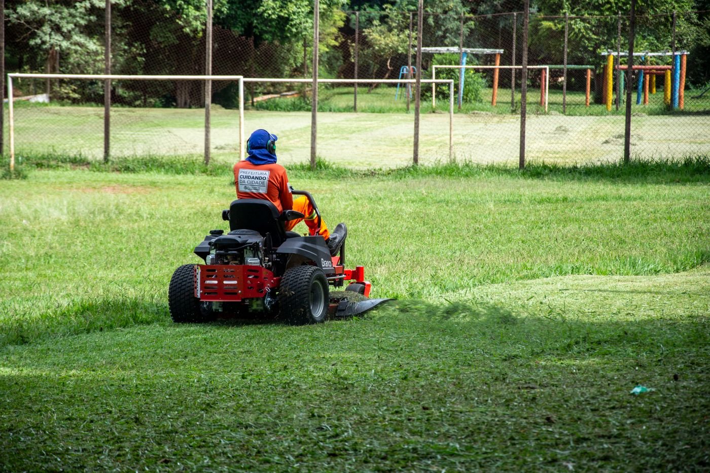 Cortador de grama em um gramado, manutenção que a grama esmeralda pede com menos frequência