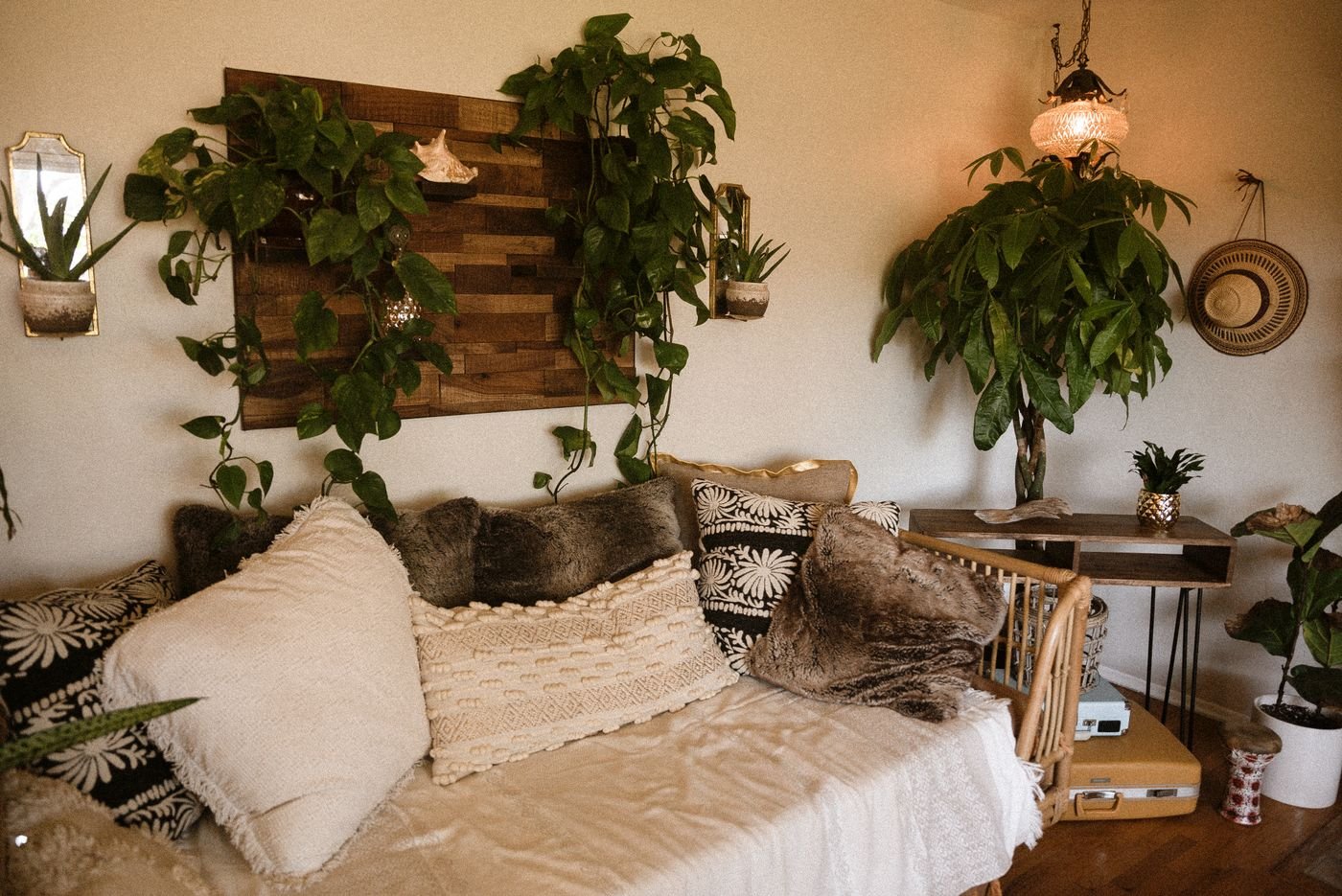 Sala no estilo boho contemporâneo com madeira, fibras naturais e muitas plantas