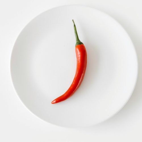 Pimenta dedo-de-moça vermelha madura sobre prato branco — cultivo de pimenta em vaso