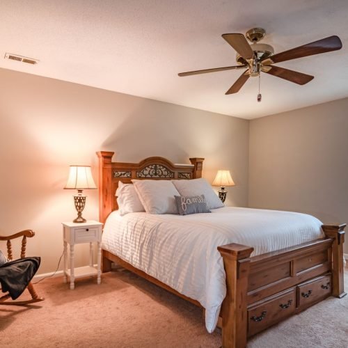 Quarto com ventilador de teto de cinco pás sobre a cama